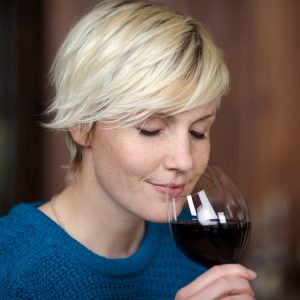closeup portrait of young blond woman drinking red wine