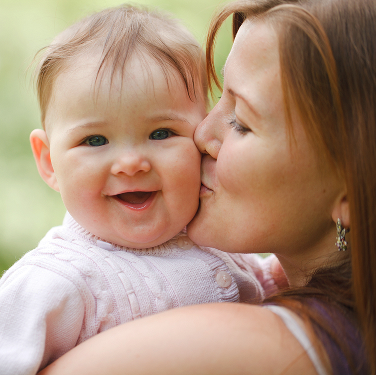 Mom kissing cute baby with love