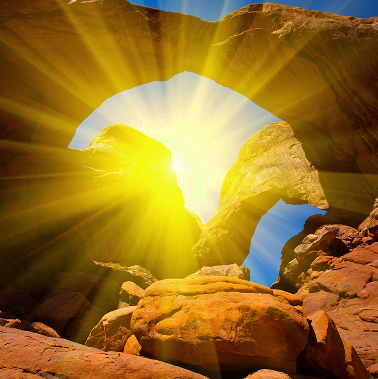 Sun shining through rock arch